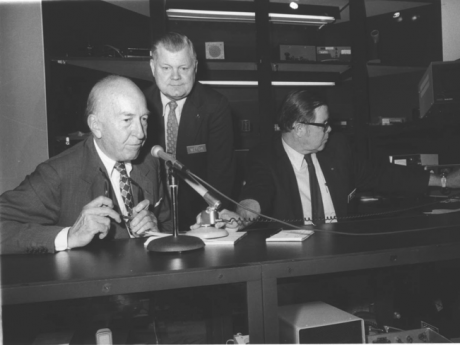 Smithsonian Secretary and two staff members sitting at a desk with a microphone